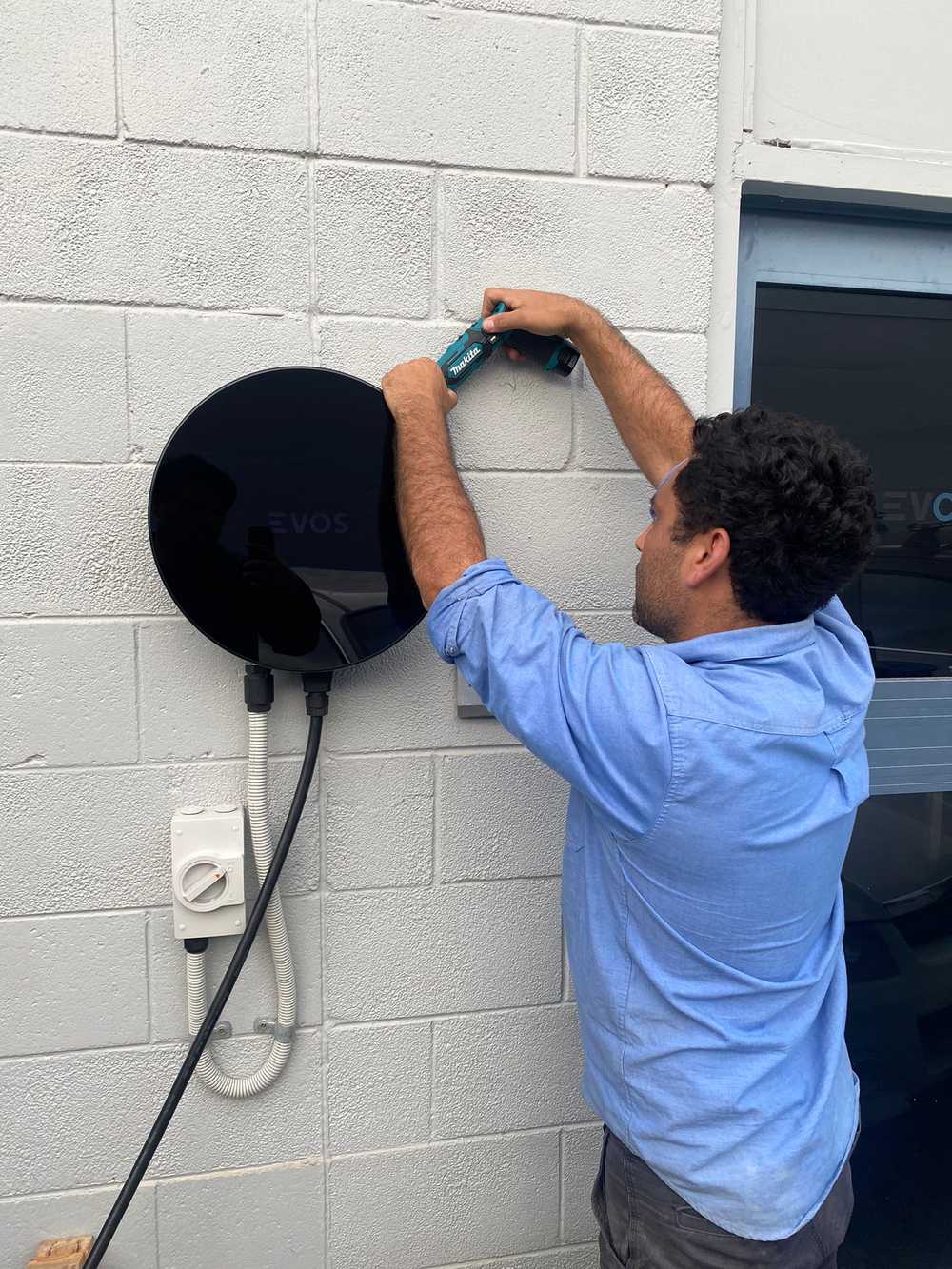 EVOS employee adjusting ev charger